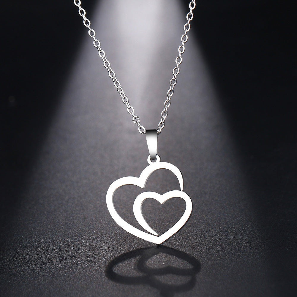 Silver necklace with a double heart pendant on a dark background