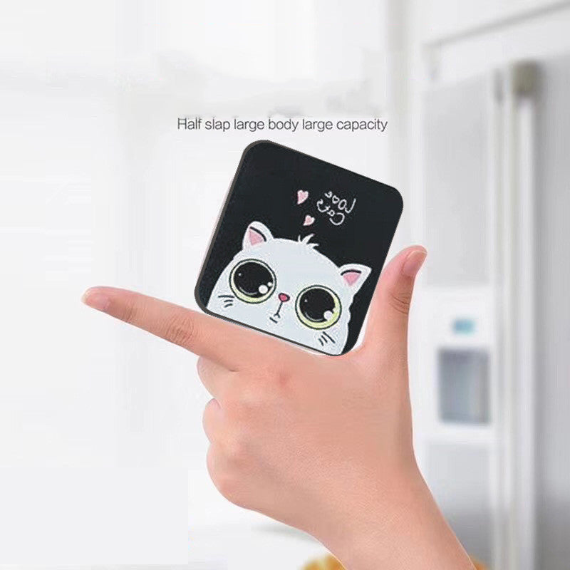 Hand holding a black power bank with a cartoon cat design against a white background