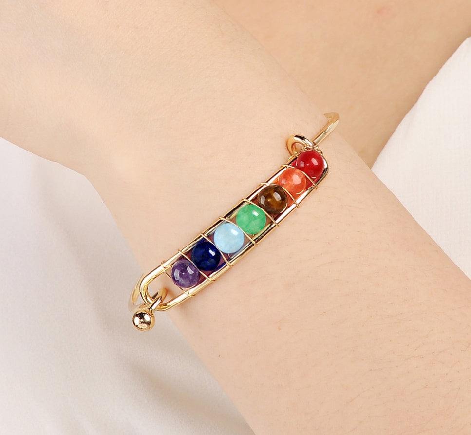 Copper plated yoga bracelet with colorful chakra gemstones on white background