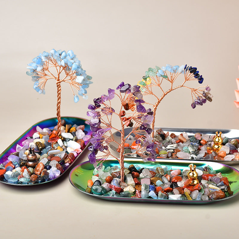 Decorative crystal trees on colorful trays with a neutral background